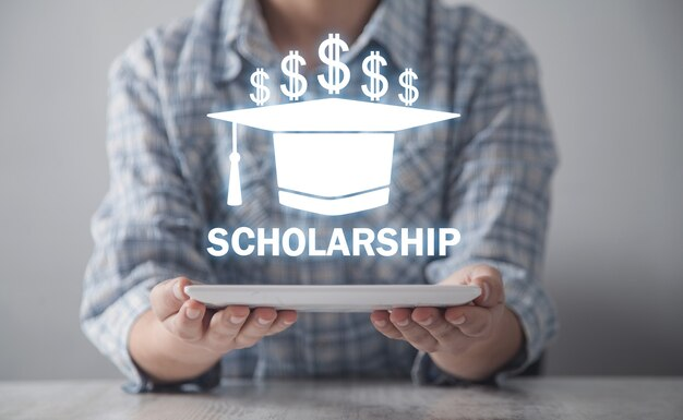 Man with tablet displaying graduation cap and dollar symbol