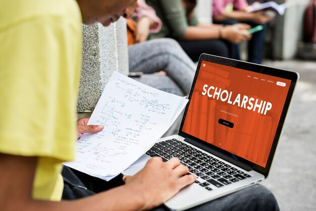 Man using a laptop with 'scholarship' displayed on the screen