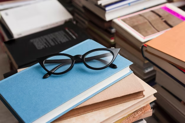 Stack of books with reading glasses atop